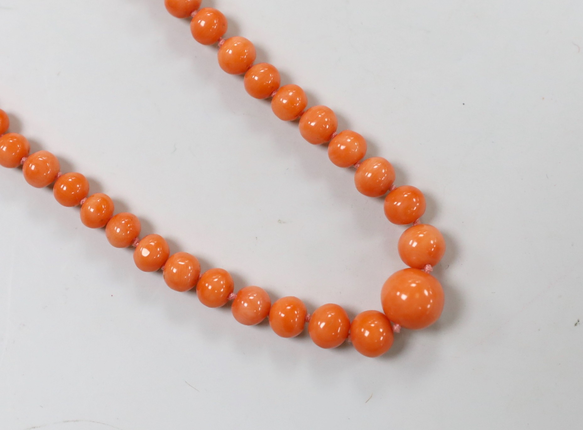 A single strand graduated coral bead necklace, with 9ct clasp, 52cm, together with a pair of coral bead earrings and a small quantity of loose coral beads.